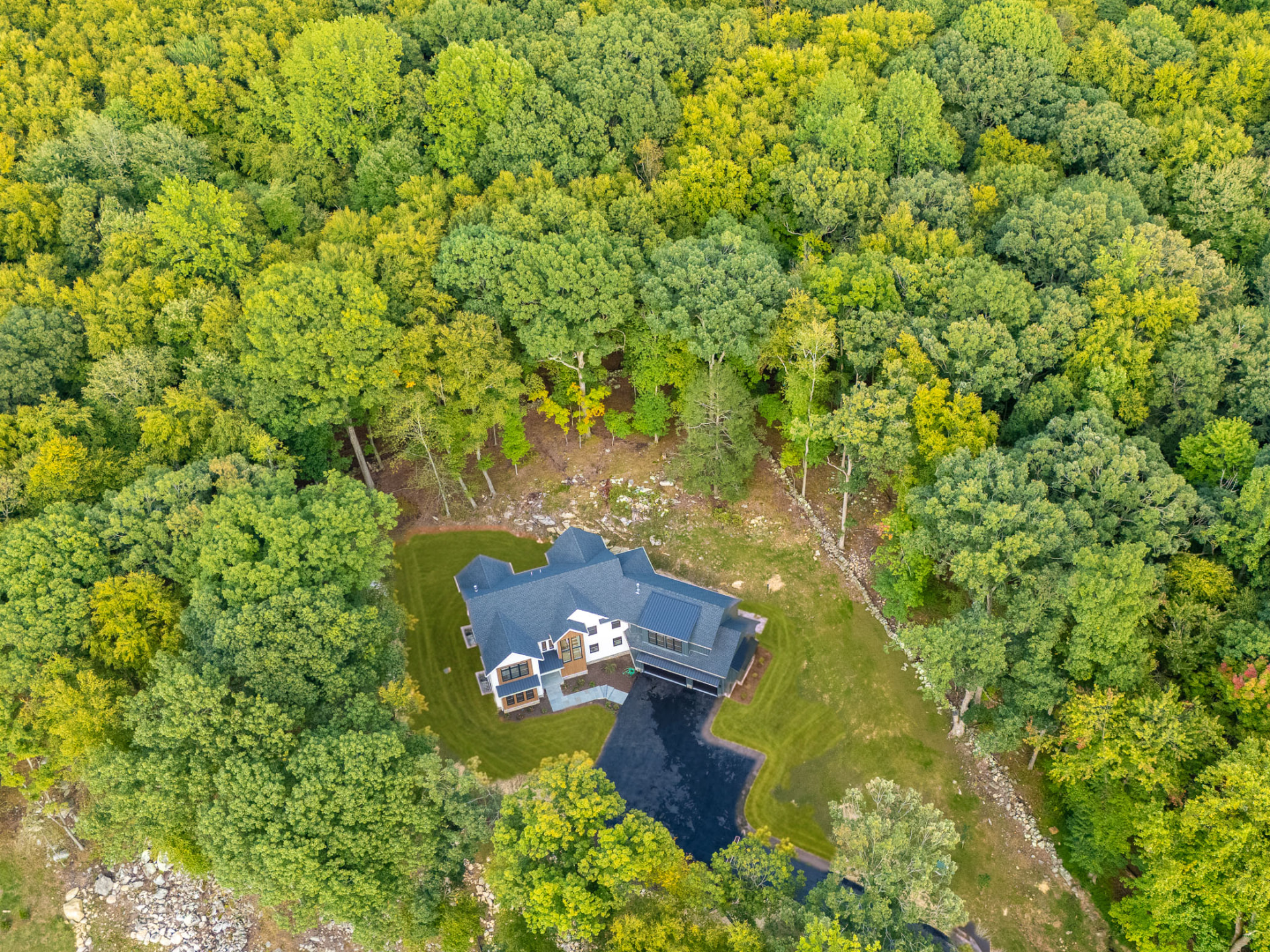 Aerial view of 108 Old Farm Rd surrounded by wooded grounds