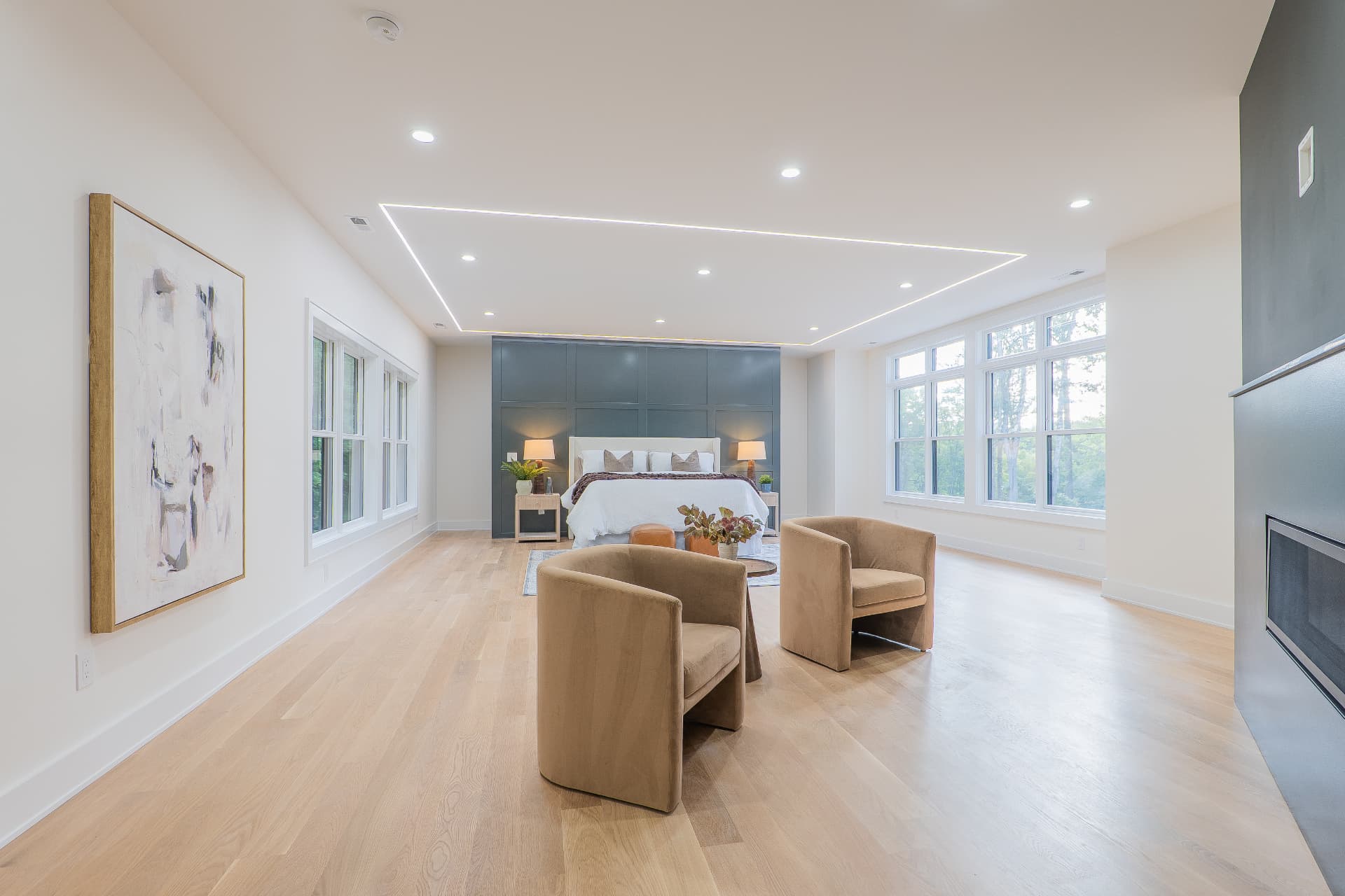 Primary bedroom suite with sitting area, fireplace and panelled accent wall