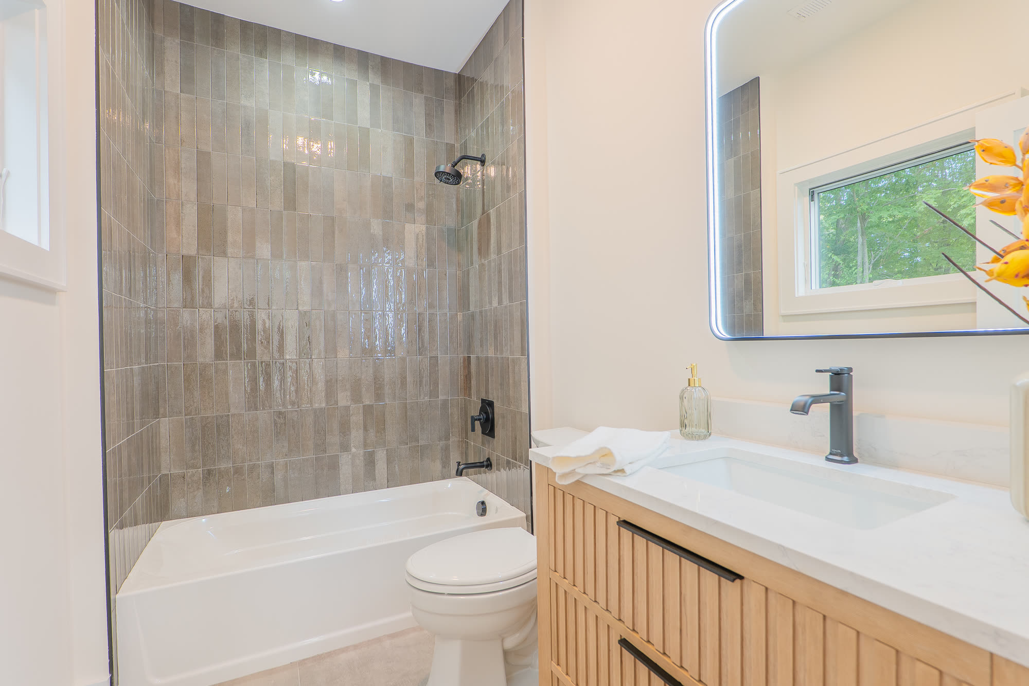 Bath with stacked tile tub surround and fluted vanity