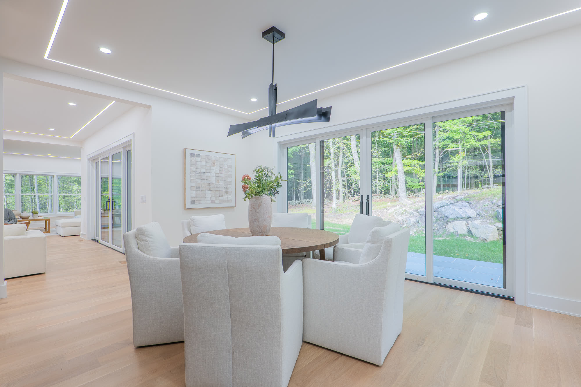 Dining area with linear pendant and yard views