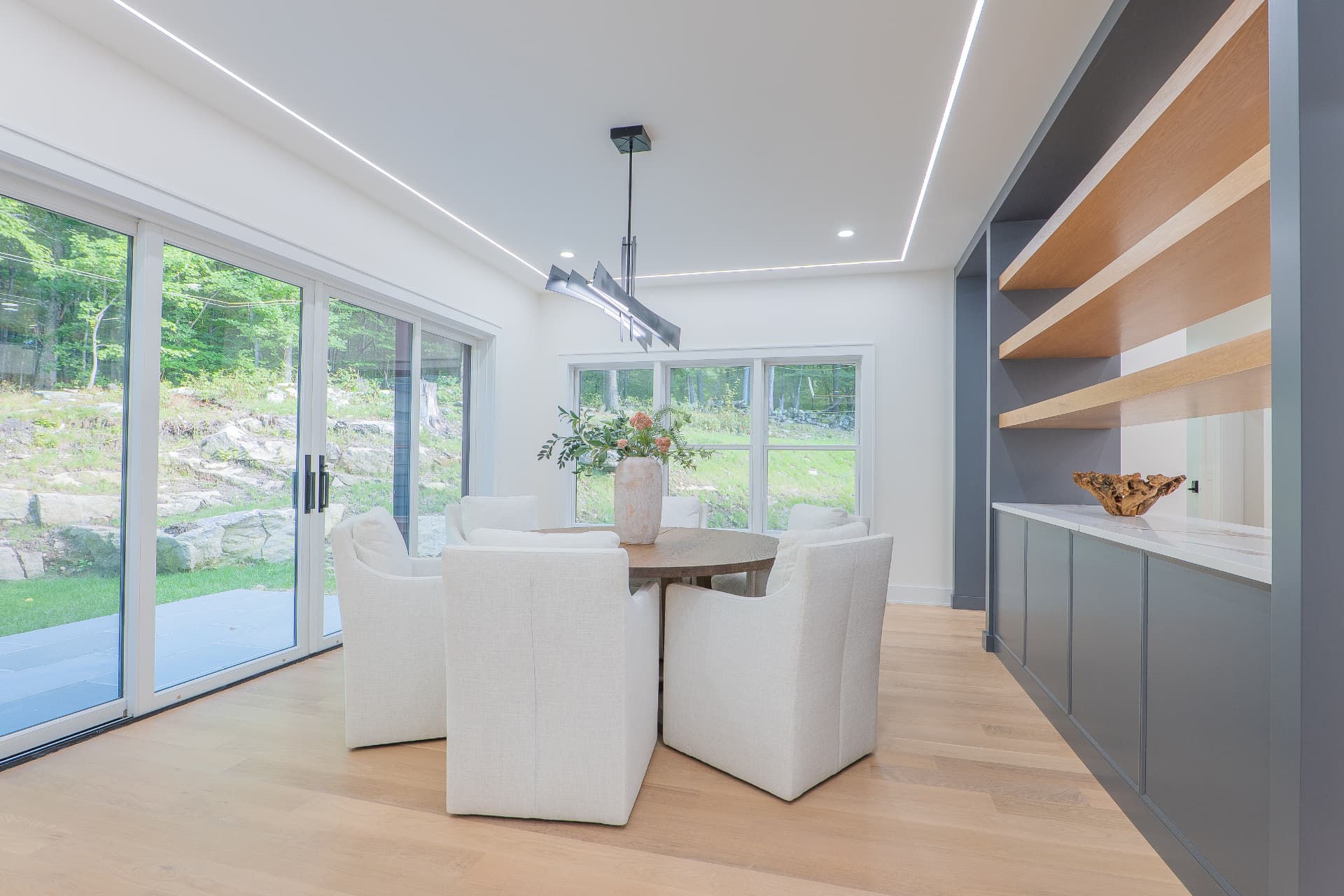 Bright dining area with built-in cabinetry and views of the wooded grounds